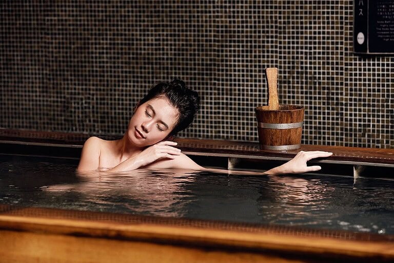 A woman relaxes in an onsen bath at Yunomori in Bangkok
