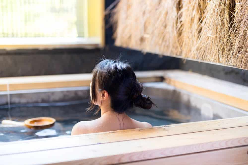 A young woman enjoying an onsen in a traditional setting