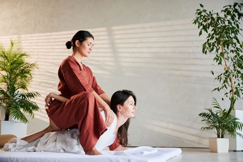 Thai masseuse uses her body to stretch a patient’s body