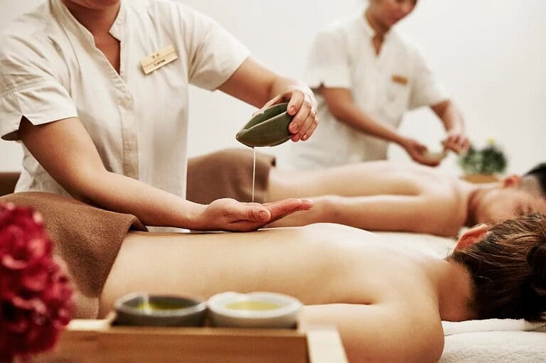 A therapist pouring oil during a body massage