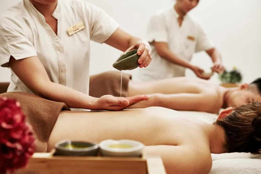 A therapist pouring oil during a body massage