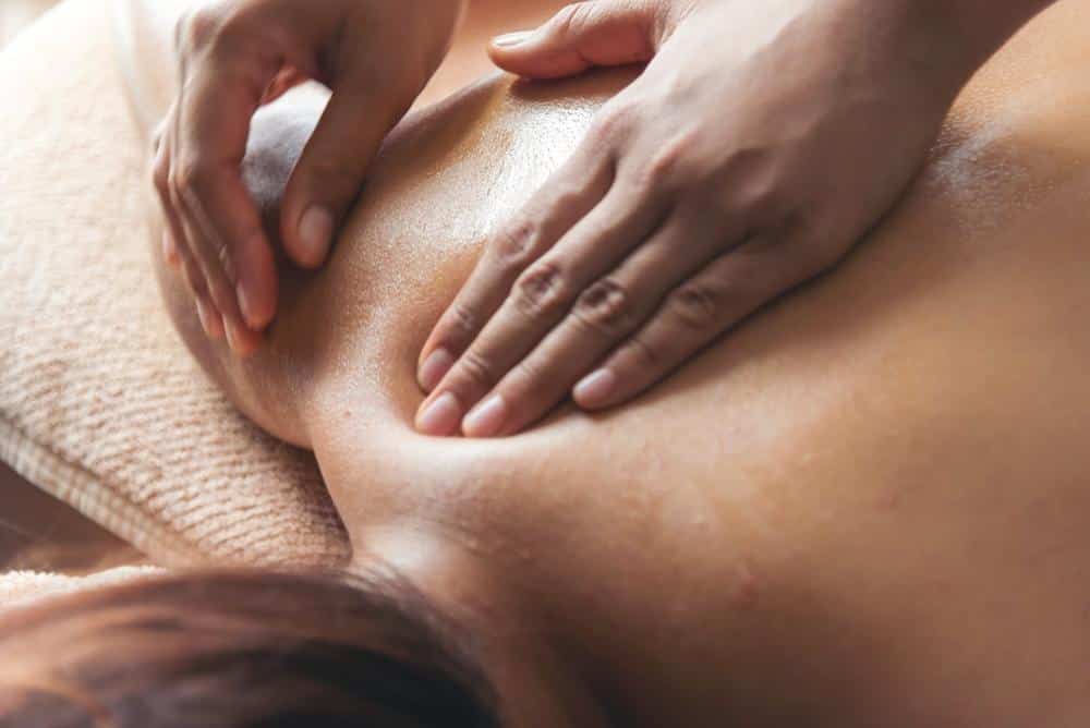 A woman getting an oil massage on her back
