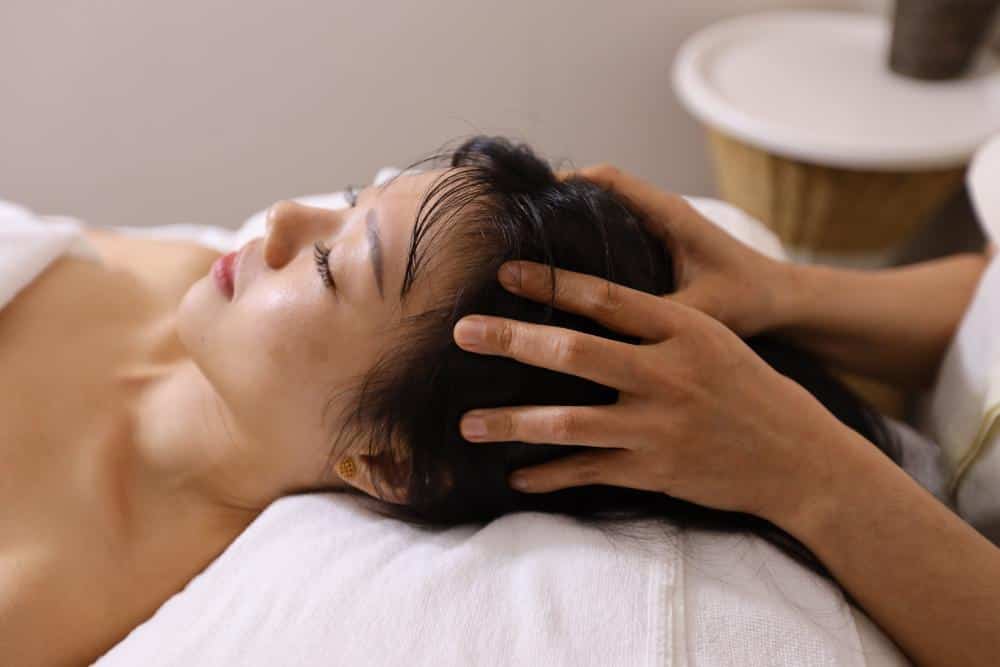 A woman receiving a head massage